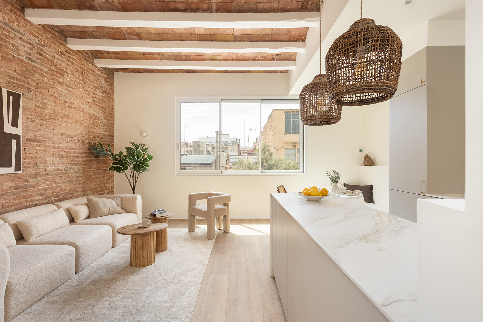 Projet Fraternitat à Barcelone — salon et cuisine avec mur en brique et îlot